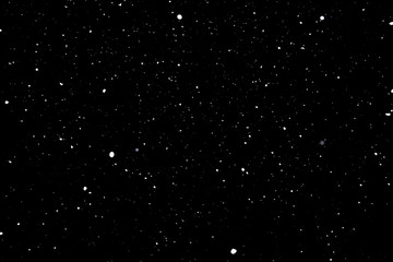 falling snow on a black background, snowfall at night, white chaotic spots on a black background