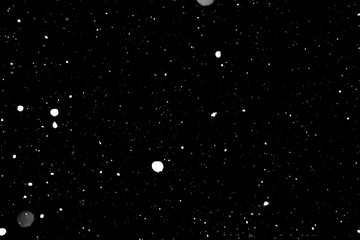 falling snow on a black background, snowfall at night, white chaotic spots on a black background