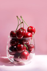 Cherries in transparent bowl, pink background. Red cherry. Fresh cherries. healthy food concept