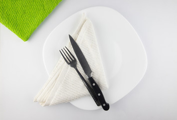 Empty white plate, spoon and knife isolated on white background. diet concept.