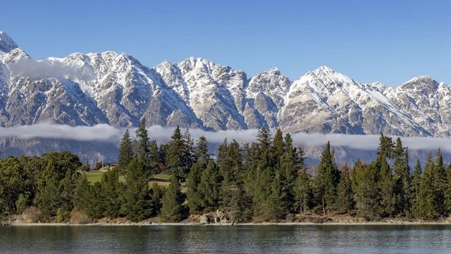 Time lapse of clouds rolling over the Remarkables and Lake Wakatipu sunny winter day in Queenstown, Otago, New Zealands