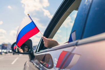 Woman or Girl Holding Russian Flag from the open car window. Concept