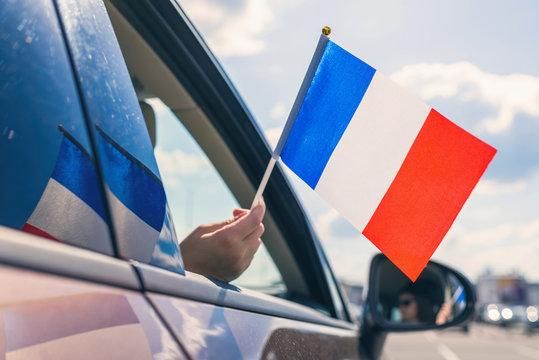 Woman or Girl Holding France Flag from the open car window. Concept