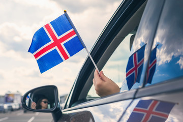 Woman or Girl Holding Iceland Flag from the open car window.  Concept