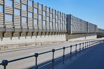 Empty Car Overpass in city on a sunny day. Noise barrage panels and pedestrian road nearby.