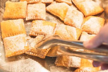 Woman choosing Cretan Sweet Pastries on a breakfast in a hotel restaurant.  Breakfast Buffet Concept