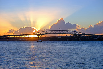Naklejka na ściany i meble amazing sunset, flare though the clouds, auckland harbor bridge, new zealand