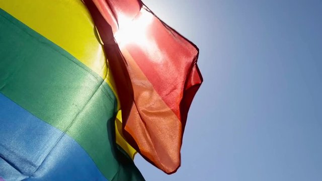 rainbow flag waving on the blue sky