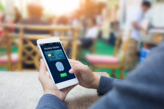 Digital Mobile Banking Wallet Concept.Hands Holding Mobile Phone On Blurred Frestaurant As Background