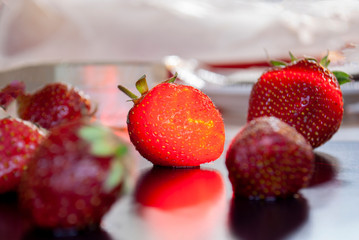 Ripe strawberries with leaves in wicker basket on table on blurred background