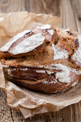 Gold rustic crusty loaves of bread and buns on wooden background. Still life captured from above top view, flat lay.