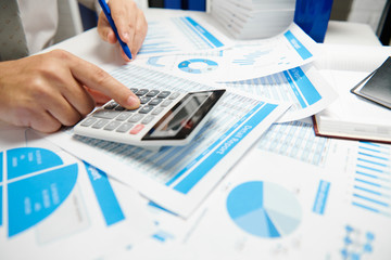 Businessman working and calculating, reads and writes reports. Office employee, table closeup. Business financial accounting concept.