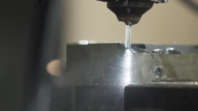 Close up EDM manufacturing process shapes metal