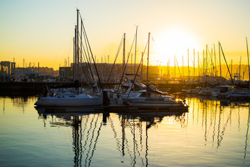 Gijon, Asturias, Spain; 09/26/2018: Sunset in the dock of Gijon, Asturias, Spain. Reflections of the boats in the water