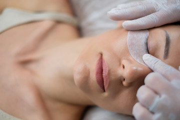 Procedure of eyelash extension in salon by cosmetician