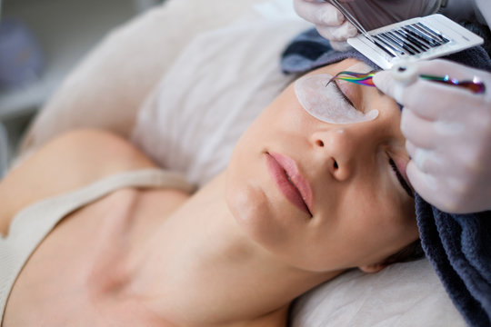 Procedure of eyelash extension in salon by cosmetician