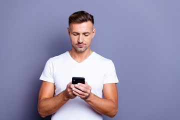 Close up photo amazing he him his middle age macho perfect appearance easy-going person not smiling telephone hands arms read instagram post wear casual white t-shirt isolated grey background