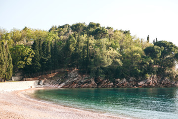Beautiful view of the natural landscape. Rocky shore with trees and sea off the coast of Montenegro.