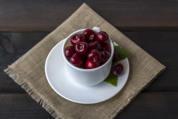 Fresh organic ripe sweet cherry in a white ceramic mug