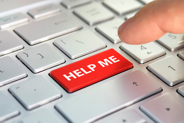 Keyboard - with a big HELP. Picture of red button on the keyboard with word of HELP ME. Finger...