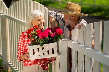 Cheerful retired man and woman living in one neighborhood speaking