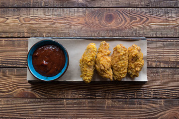 Fried chicken with sauce on a wooden table.