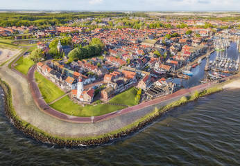 Aerial view of Urk with its lighthouse, a small coastal village on the IJsselmeer in the Netherlands.. - obrazy, fototapety, plakaty