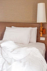 White crumpled bed sheet and two messy pillows in a hotel room