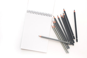 Notebook with pencils on a white background. Top view
