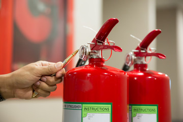 Close-up Image the red fire extinguishers,Engineering is checking the fire extinguisher to be ready...