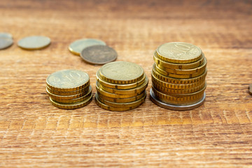 Staked coins growing, increase, changing euro pile pack heap on a wooden background mock up selective focus close up
