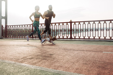 Active young couple jogging with a dog. Morning running with pet. Sport for all family. Morning...