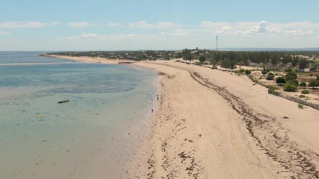 Anakao beach, South West Madagascar. Aerial footage of the coastline with boats on anchor and people on beach . 