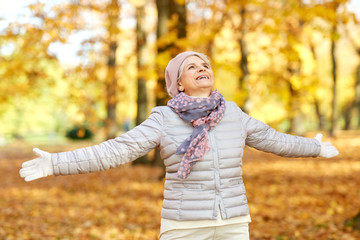 old age, retirement and season concept - happy senior woman enjoying beautiful autumn outdoors