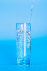 Close up pouring purified fresh drink water from the bottle on table