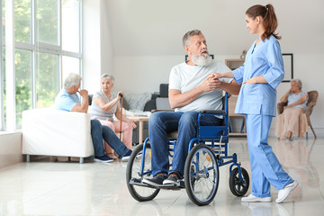 Fototapeta na wymiar Elderly man with caregiver in nursing home