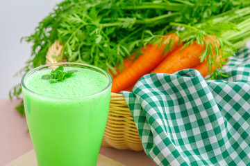 Green smoothie in glass over rustic wooden background
