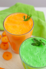 Green smoothie in glass over rustic wooden background