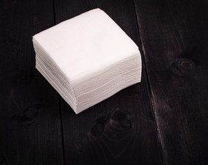 The white paper napkin on old black wooden table