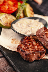 grilled beef steak with vegetables on gray slate background