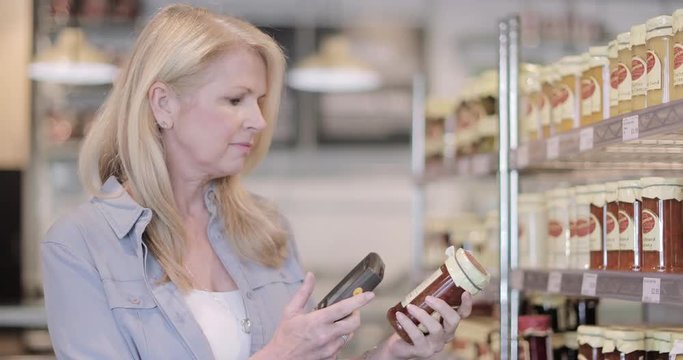Senior female using self scan in a grocery store