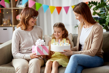 family, generation and celebration concept - smiling mother, daughter and grandmother with gift box...
