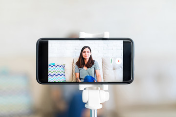 Female influencer and blogger recording herself in a smartphone