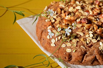 Vegan homemade pie made of integral flour without sugar on a yellow background decorated with gypsophila plant