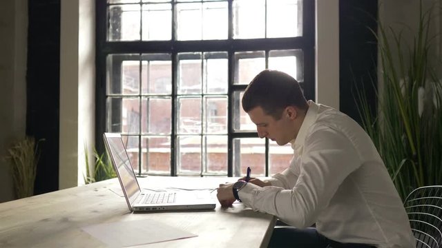 businessman working with a laptop in the office by the window