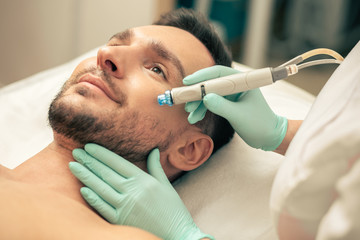Young man looking calm during the painless skin procedure