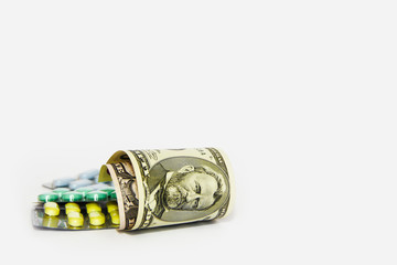 multi-colored medicinal pills, thermometer, syringe and dollars