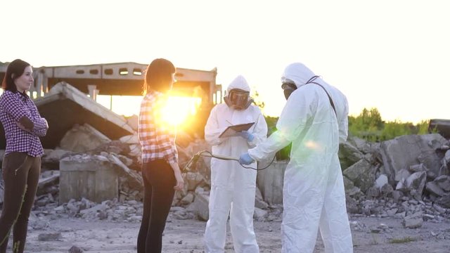 portrait scientists in protective suits and masks and dosimeter ,measure radiation and affected people