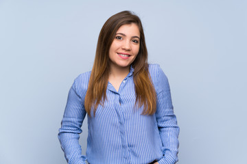 Young girl over isolated blue wall laughing