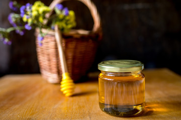 gold honey in glass jar with dipper